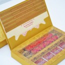 Gold box containing red satin scroll and chocolates